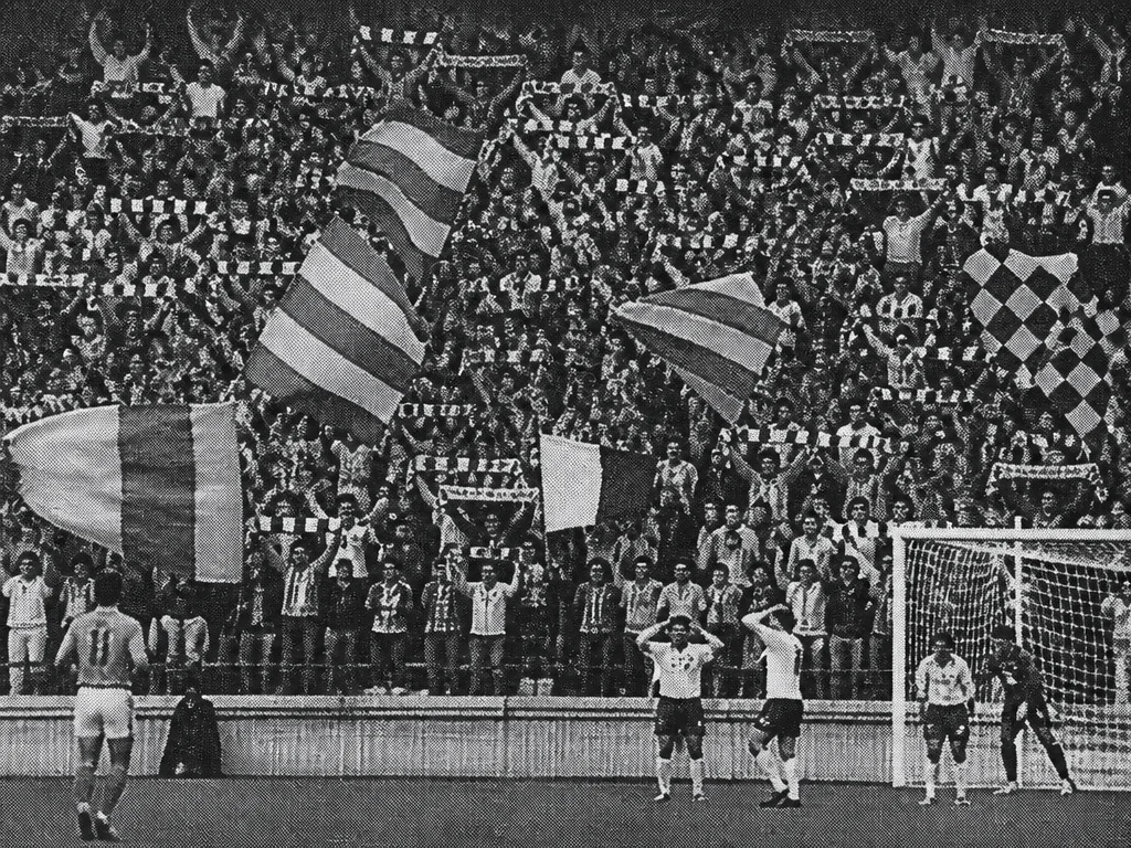 Rastrerat svartvitt tidningsfoto av en fullsatt stadionläktare vid en allsvensk match