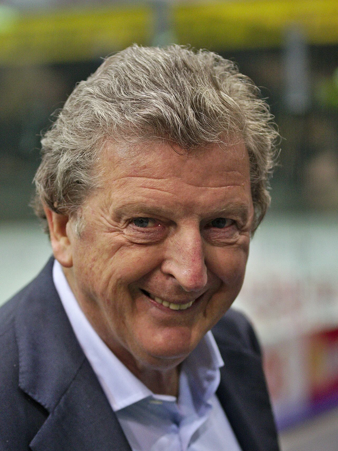 Roy Hodgson ler in i kameran, klädd i mörk kavaj och ljus skjorta
